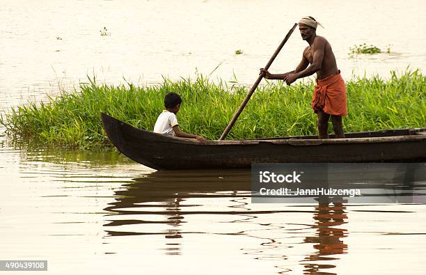 Kerala India Fisherman Child And Canoe In Kerala Backwaters Stock Photo - Download Image Now