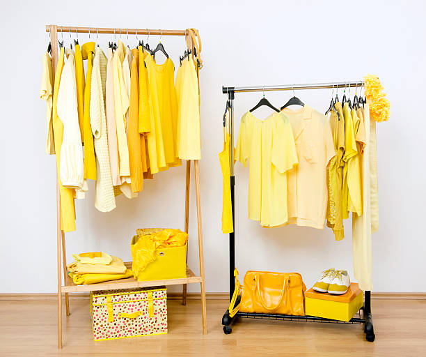 istock Dressing closet with yellow clothes arranged on hangers. 490453119