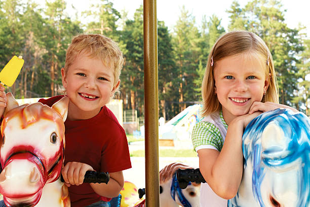istock brother and sister ride the carousel 490458309