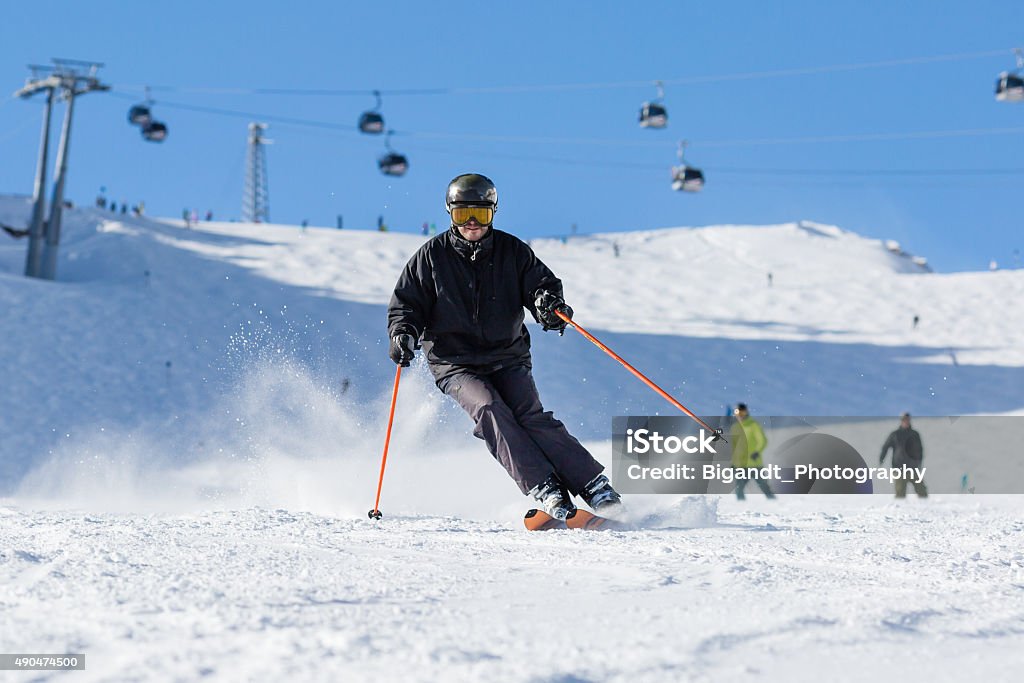 Skier skiing on ski slope Male skier skiing in fresh snow on ski slope on a sunny winter day at the ski resort Soelden in Austria. 2015 Stock Photo