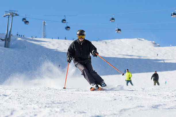 Skier skiing on ski slope Male skier skiing in fresh snow on ski slope on a sunny winter day at the ski resort Soelden in Austria. tiefenbach stock pictures, royalty-free photos & images