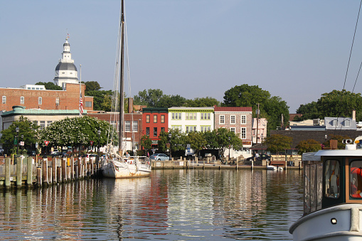 Annapolis, Maryland, USA- August 9, 2012: View of the Annapolis Harbor in the historic colonial City of Annapolis, Maryland.  The United States Naval Academy Chapel is located in Annapolis.  Boats docked in Ego Alley on Spa Creek off the Severn River, a tributary of the Chesapeake Bay.   Tourists stroll and relax on City Dock.  Annapolis is a historic waterfront town on the east coast of the USA.  Annapolis City Dock is nearby.  Photo was taken from a power boat underway in the Harbor.