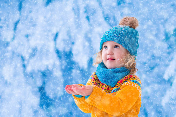 istock Little girl catching snow flakes 490478512