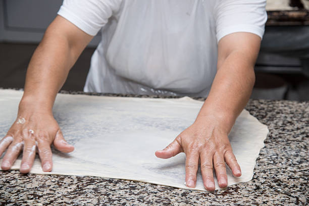 istock close up of female hands kneading dough and making banitsa 490480458