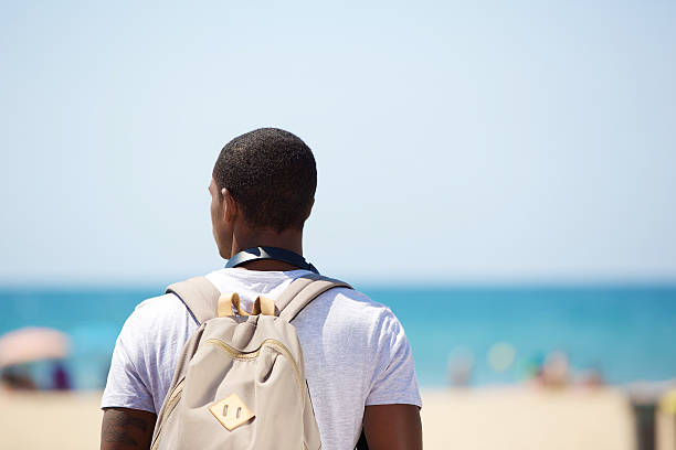 istock African american man standing at the beach with bag 490481646