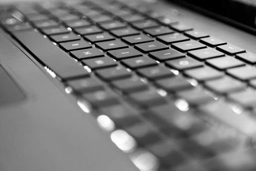Showing the keyboard of a laptop in black and white