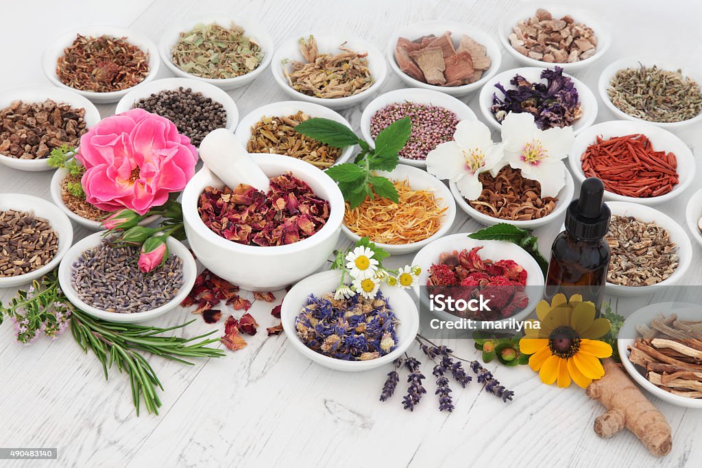 Natural Health Regime Natural herb and flower selection used in herbal medicine with medicinal dropper bottle and mortar with pestle  over distressed wooden background. 2015 Stock Photo