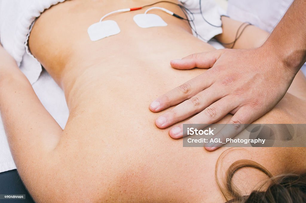 Hand and electrodes on a patient's lumbar Electrode Stock Photo