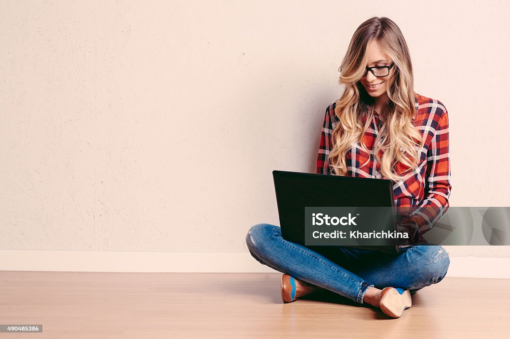 Young creative woman sitting in the floor with laptop Young creative woman sitting in the floor with laptop./ Casual blogger woman 2015 Stock Photo