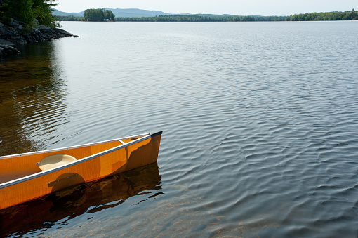 A yellow Kevlar canoe sits on the shore of Lake Umbagog, on the Maine and New Hampshire border.