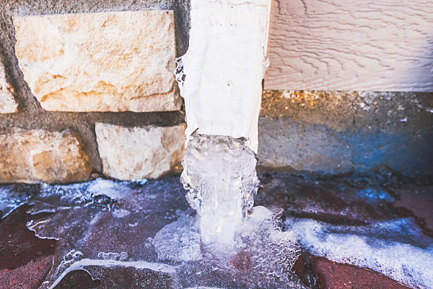 downspout водой положилась на льду в «снежная буря» - melting ice icicle leaking стоковые фото и изображения