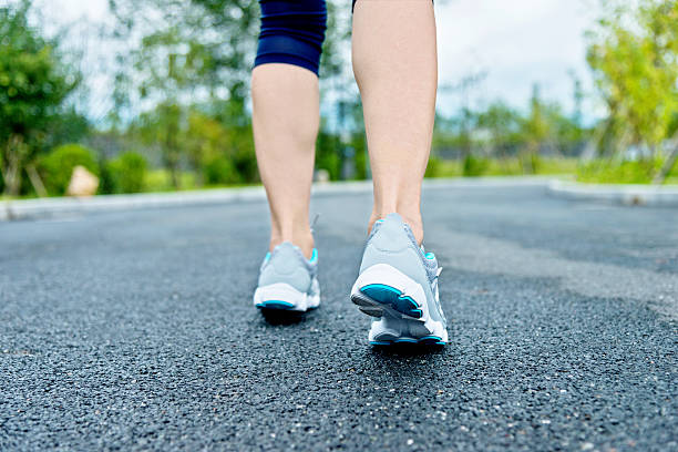 istock Woman's running shoes on asphalt road 490507770