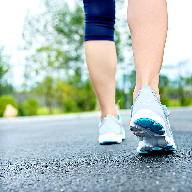 istock Woman's running shoes on asphalt road 490507826