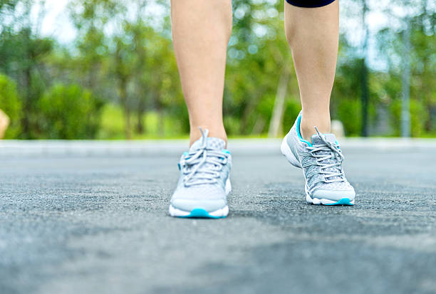 istock Woman's running shoes on asphalt road 490508482