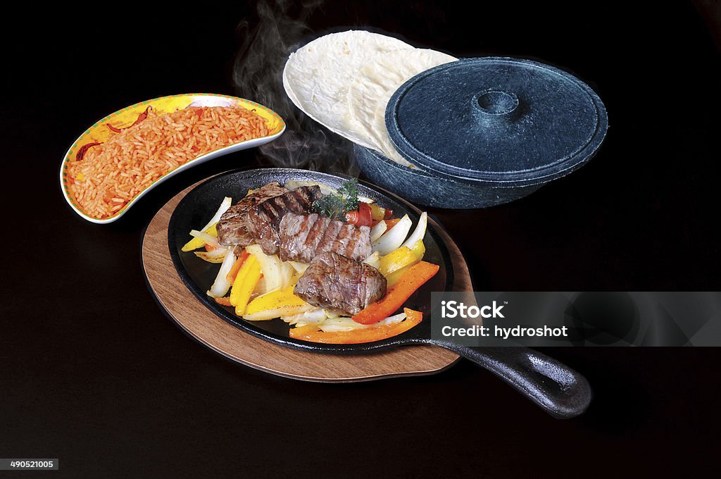 Tequila Beef Fajitas Tequila marinated slices of beef, spicy rice with tomato sauteed onion and bell peppers Fajita Stock Photo