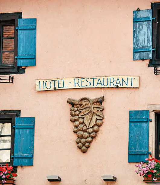 Facade sign of French restaurant with ancient grape decoration - wine specialized traditional restaurant