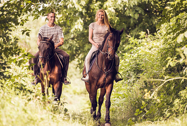 istock Smiling couple horseback riding in nature. 490543044