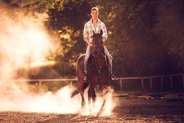 istock Young man ridding a stallion and looking at camera. 490544102