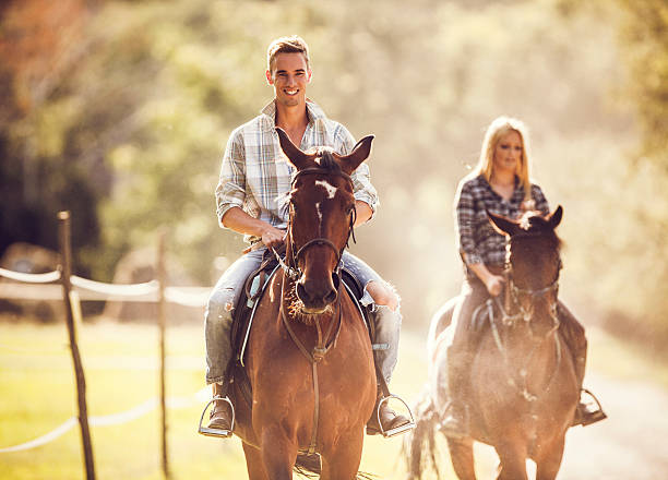 istock Young man riding horses with his girlfriend in nature. 490544392
