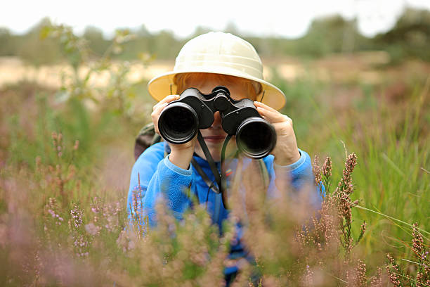 Boy in Pith Helmet Looking Through Binoculars Outdoors