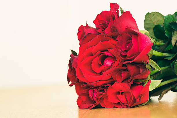istock Red rose on wooden table 490553080
