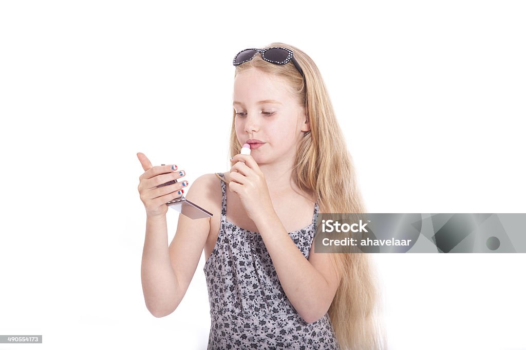 young blond girl with sunglasses applying lipstick in studio young blond girl applying lipstick in studio against white background Adult Stock Photo