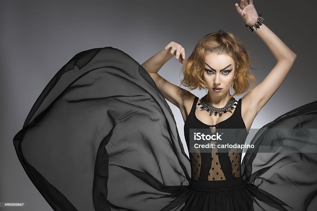 fashion grotesque girl fashion portrait of pretty girl with bizarre gothic style, make-up and accessories and big flying skirt. Carnival look Adult Stock Photo