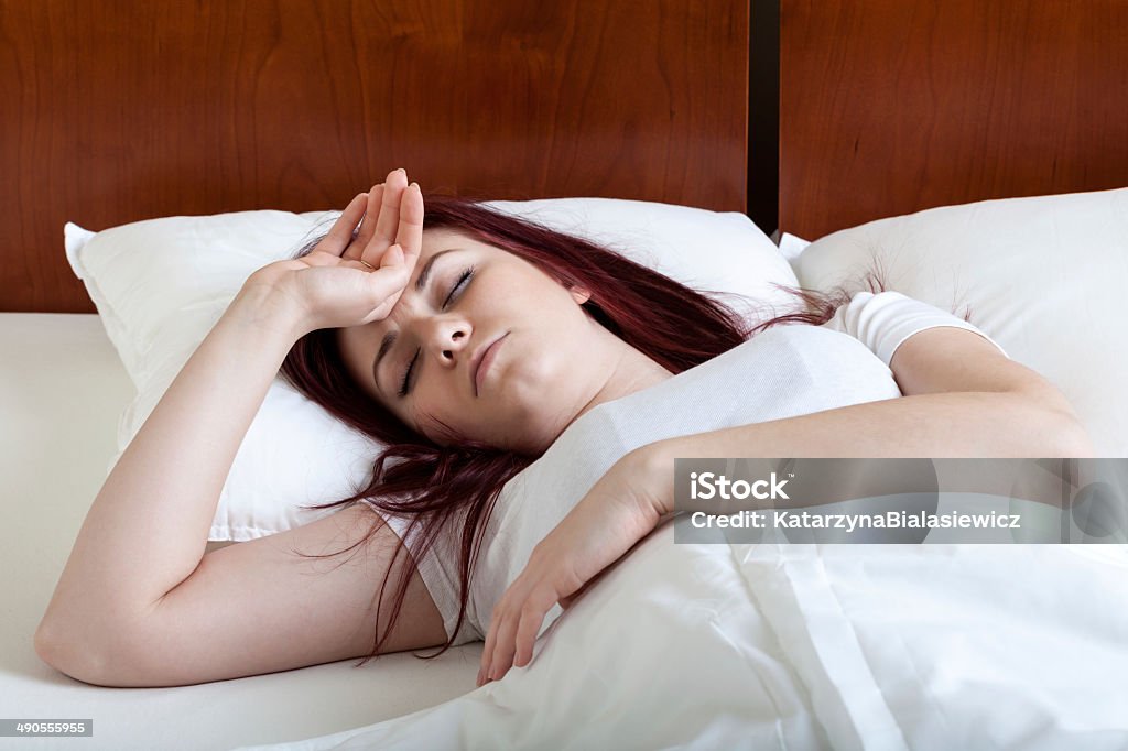 Woman with fever lying in bed Woman with high fever lying in bed Adult Stock Photo