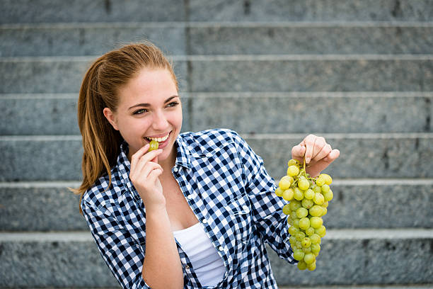 istock Young woman eating  grapes 490556168