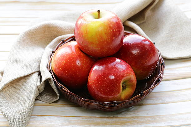 istock Red ripe apples in a wicker basket on a wooden table 490559985