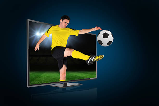 istock Football player kicking ball through tv 490575741