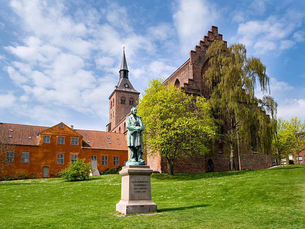 Sculpture statue of Hans Christian Andersen Odense Denmark Sculpture statue of Hans Christian Andersen in front of sct Knud cathedral, Odense Denmark statue of hans christian andersen stock pictures, royalty-free photos & images