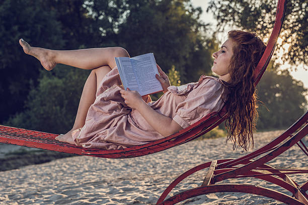 istock Side view of a young woman reading a book. 490577524