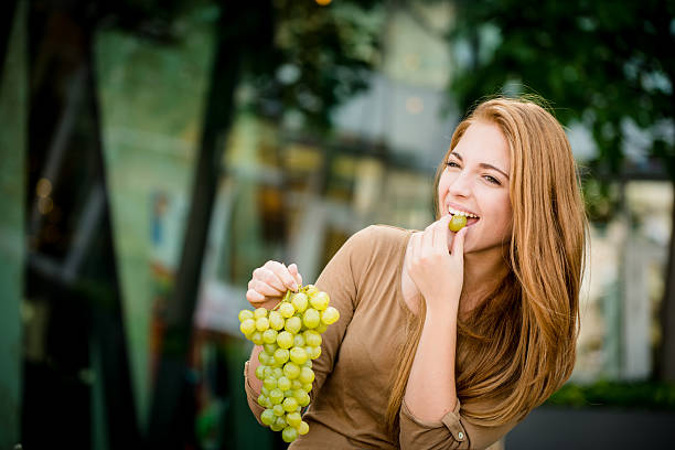 Teenager eating  grapes stock photo