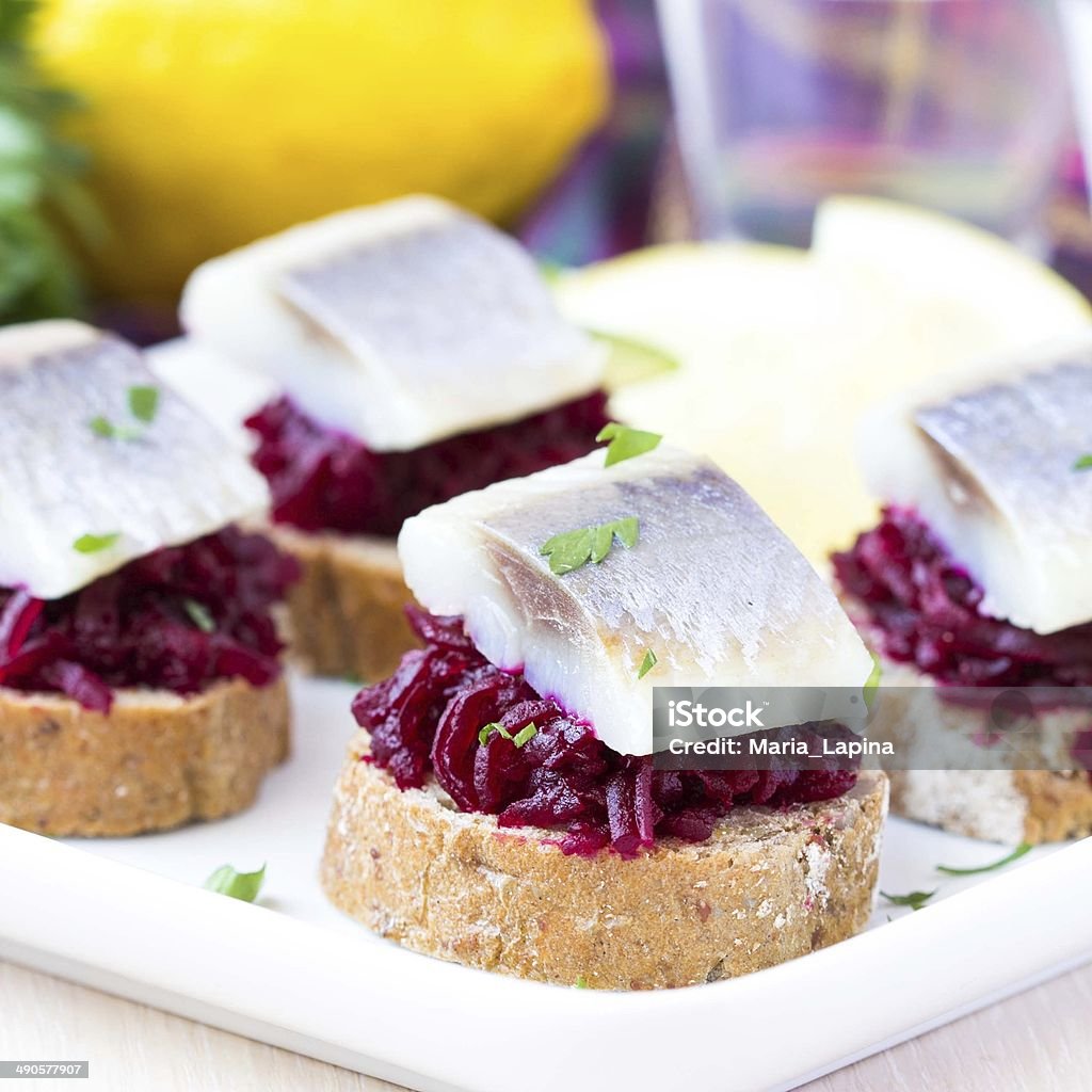 Canape herring with beets on rye toast, tasty starter, appertise Canape herring with beets on rye toast, lemon and parsley, delicious starter, appertiser Appetizer Stock Photo