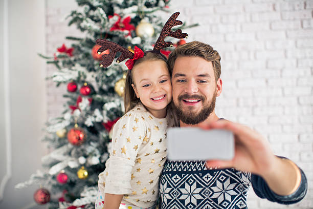 istock Father and his cute daughter taking selfies for christmas. 490578040