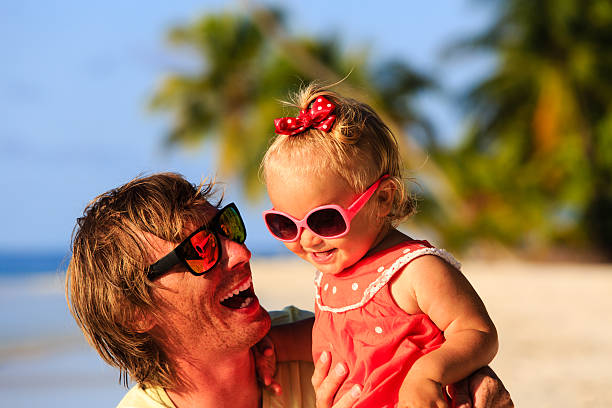 istock father and cute little daughter at beach 490578698