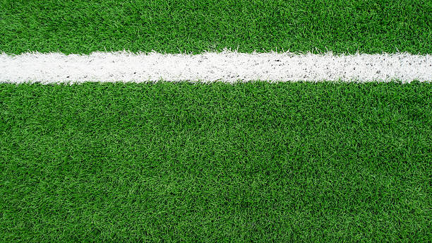 istock White stripe on the green soccer field from top view 490583398