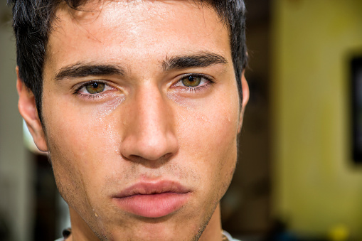 Close up Face of a Pensive Handsome Young Man with Tears on his Face, Looking at Camera, Worried or Sad.