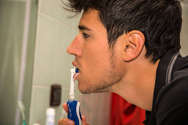 photo de jeune homme se brosser les dents avec une brosse à dents - smiling human teeth toothbrush moving up photos et images de collection