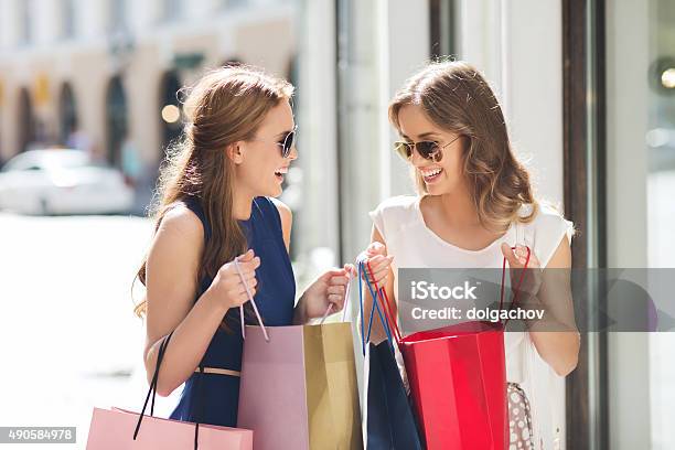 Photo libre de droit de Femmes Heureux Avec Des Sacs De Shopping Dans La Ville banque d'images et plus d'images libres de droit de Faire les courses