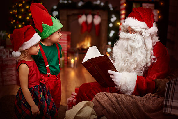 istock Mysterious santa claus reading a book with children 490586876