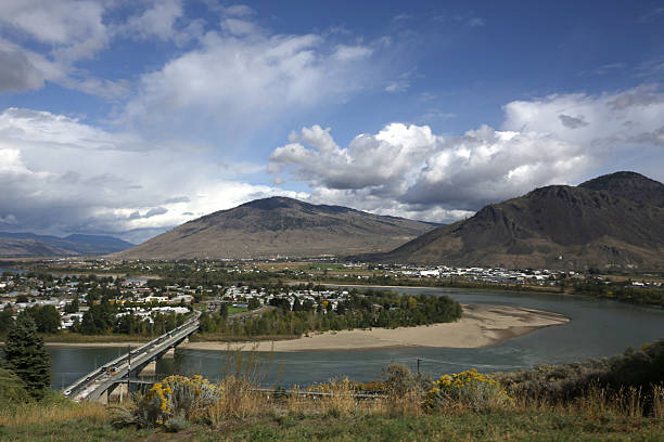 Thompson River and Overlanders Bridge, Kamloops, British Columbia, Canada Thompson River and Overlanders Bridge, Kamloops, British Columbia, The North Thompson River and Thompson River converge north of downtown Kamloops. Canada. Blue sky with dramatic clouds on an autumn day. Scenic view of Thompson Valley in the Thompson-Nicola Regional District.  kamloops stock pictures, royalty-free photos & images