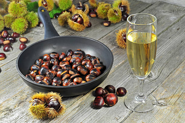 Roasted chestnuts with glass of white wine stock photo