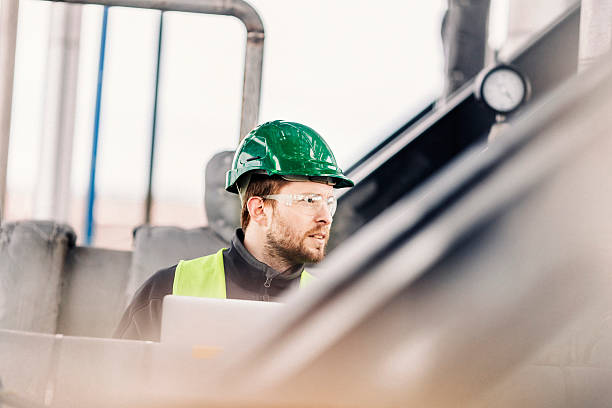 istock Manual worker looking at machines in factory 490590842
