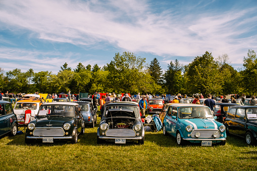 Burlington, Ontario, Canada - September 20, 2015. British Car Day is a classic car show hosted annually by the Toronto Triumph Club at one of the public Parks (Bronte Park) in Burlington (suburbs of Toronto), on the third Sunday of September. Classic Mini cars parked in the line up. Visitors walking around, checking vehicles on display. Since its inaugural event in 1984, it has grown in leaps and bounds, and now draws over 1,000 British cars and 8,000 spectators, with room to grow even bigger. British Car Day is open to vintage, classic and current British manufactured vehicles, including motorcycles. 