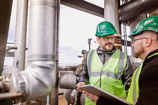 istock Male workers discussing by machine at industry 490592374