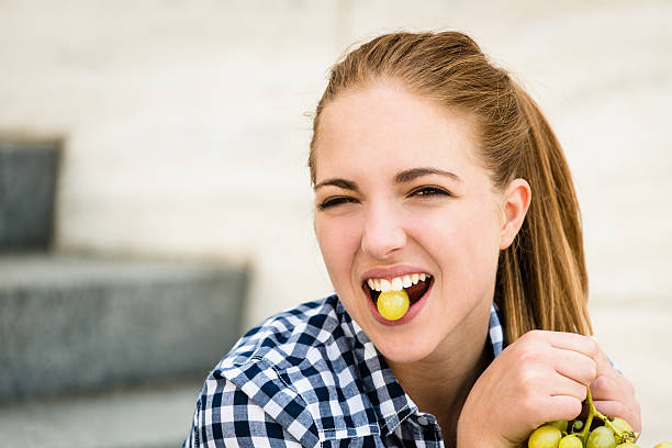 istock Young woman eating  grapes 490592740