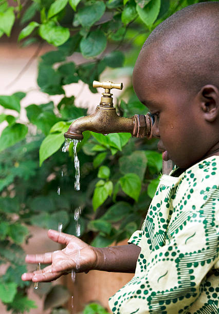 istock African Boy Holds Hands under Tap to collect Water 490607082