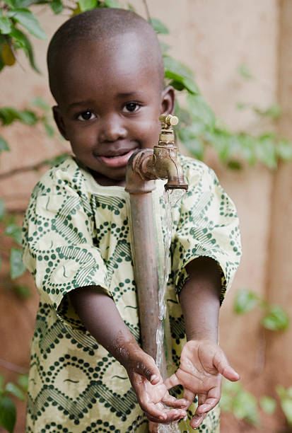 istock Happy African Child Holding Hands Under Tap Water Symbol 490607300